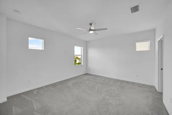 an empty room with a window and a ceiling fan