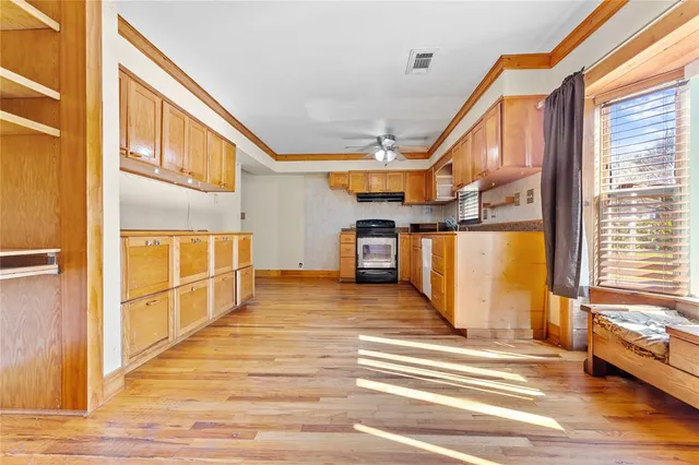 a view of a living room with wooden floor and a window