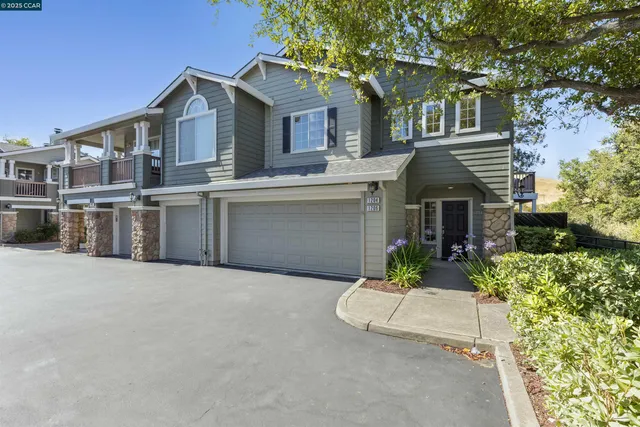 a front view of a house with yard and parking