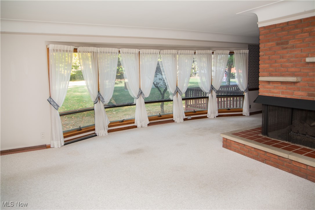 10050 New Buffalo Road Canfield, OH 44406 - Photo 8 of 49 Unfurnished living room with a brick fireplace and carpet