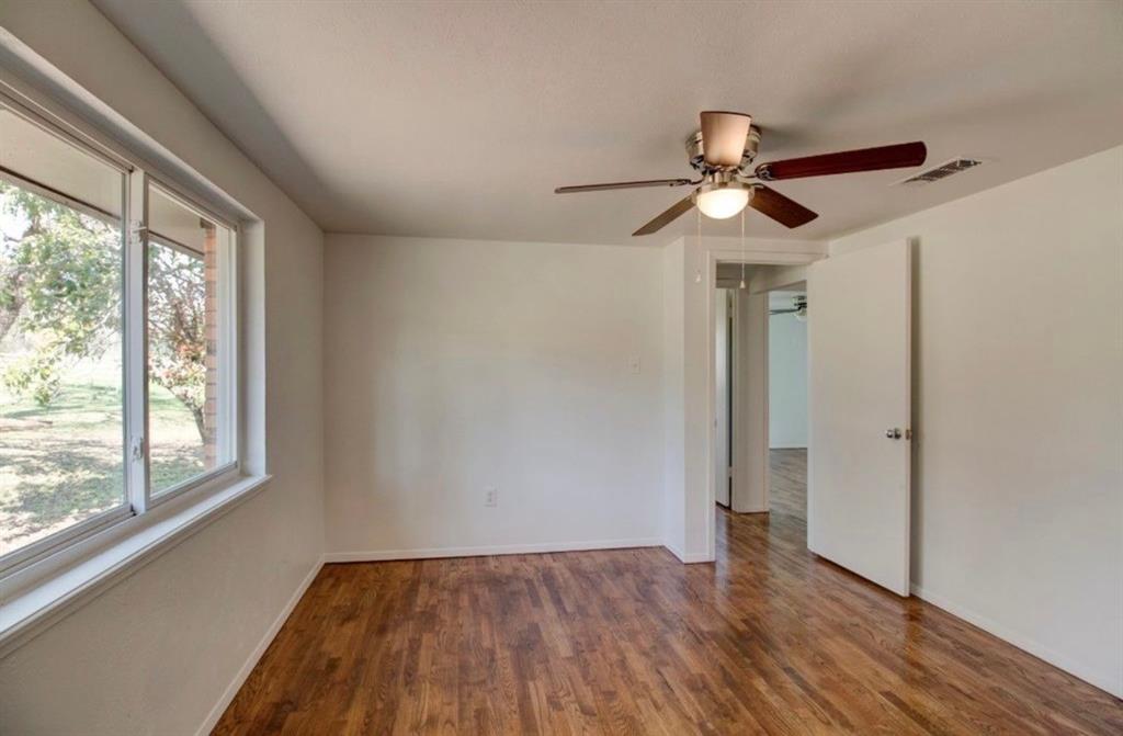 3900 Moseley Road Cross Roads, TX 76227 - Photo 17 of 36 Spacious room featuring wood-finish flooring, a contemporary ceiling fan with integrated lighting, and multiple large windows