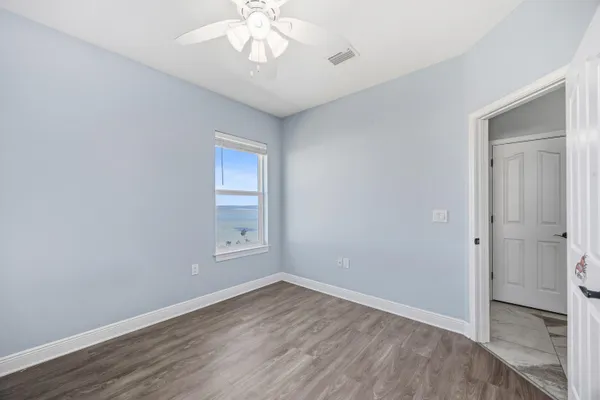 an empty room with window and ceiling fan
