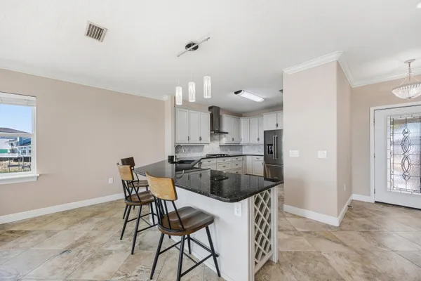 a kitchen with a dining table chairs and a refrigerator