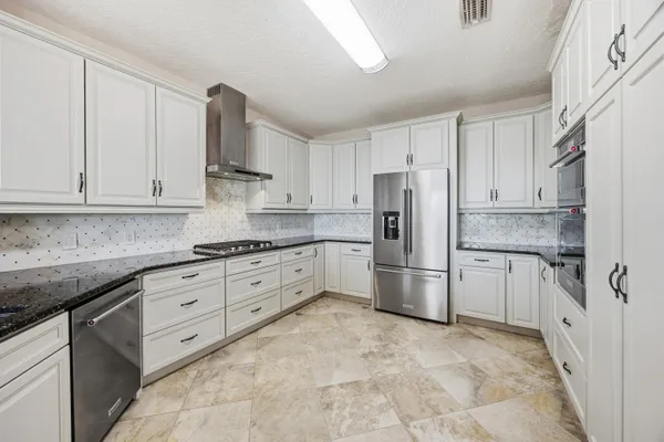 a kitchen with stainless steel appliances granite countertop a refrigerator sink and cabinets