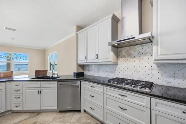 a kitchen with white cabinets and appliances