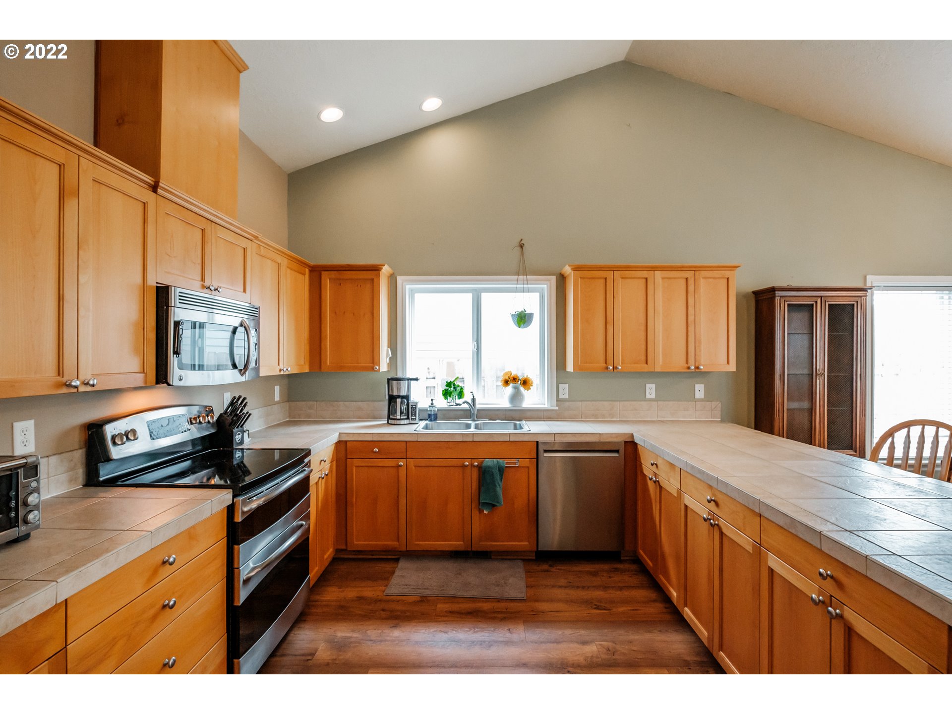 3778 10th Street Hubbard, OR 97032 - Photo 11 of 32 a kitchen with stainless steel appliances granite countertop a sink a stove and cabinets