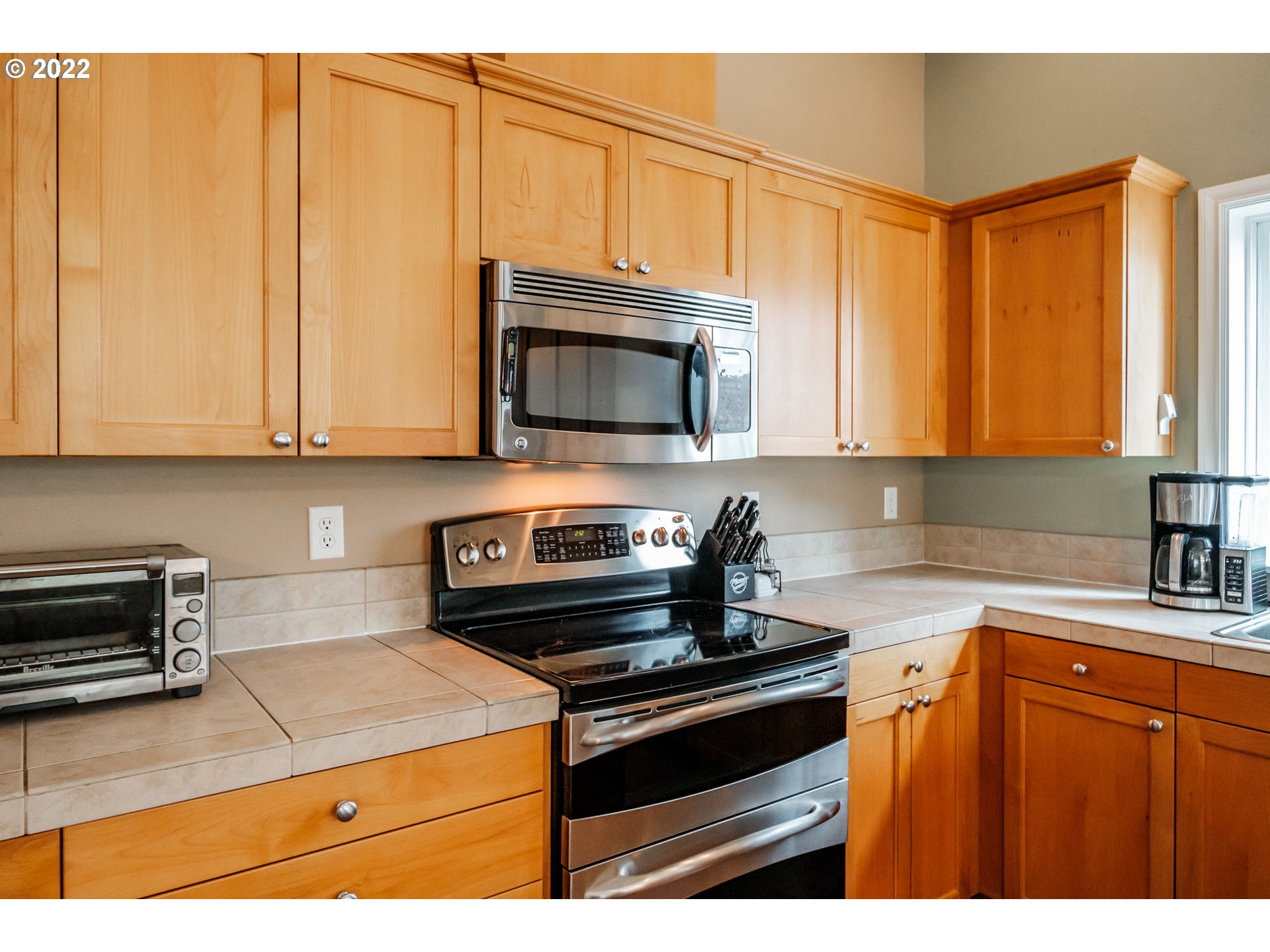 3778 10th Street Hubbard, OR 97032 - Photo 12 of 32 a kitchen with stainless steel appliances granite countertop a stove a microwave and a sink