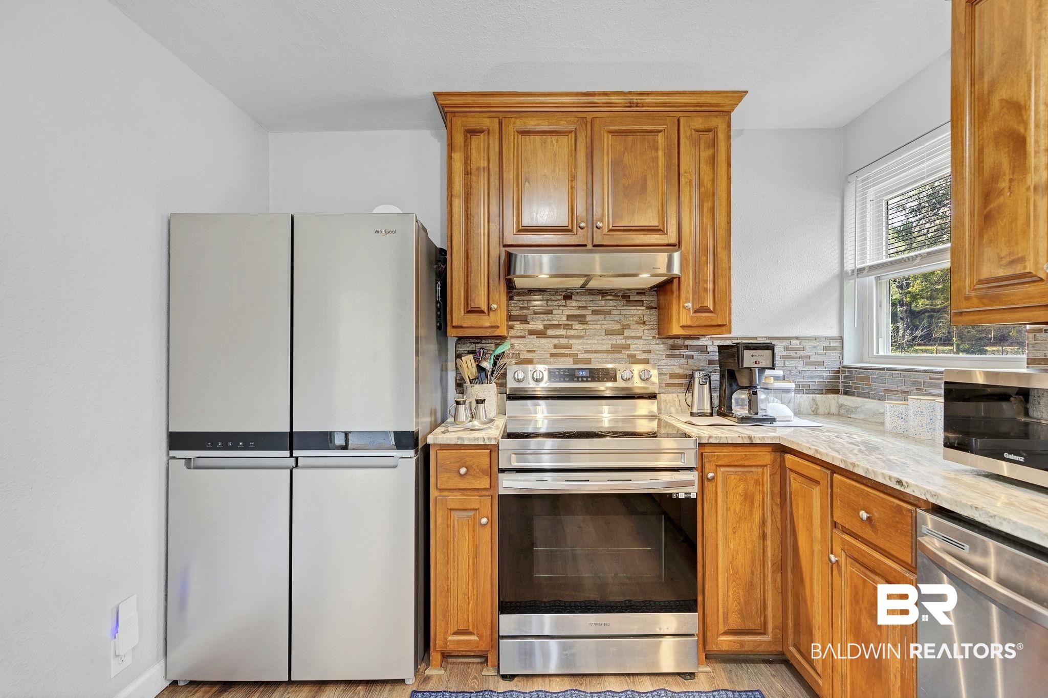 4690 Lott Road Eight Mile, AL 36613 - Photo 19 of 45 Kitchen with stainless steel appliances, light stone countertops, and backsplash