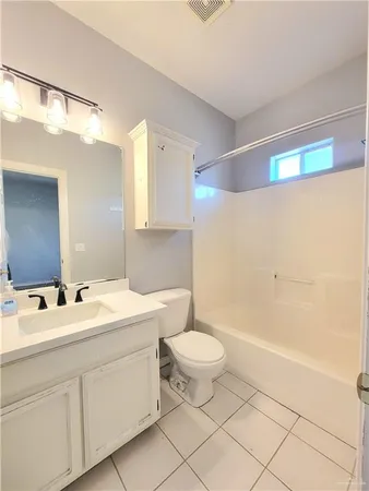 a bathroom with a double vanity sink a toilet and a mirror