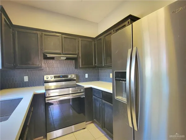 a kitchen with stainless steel appliances a refrigerator and a stove top oven