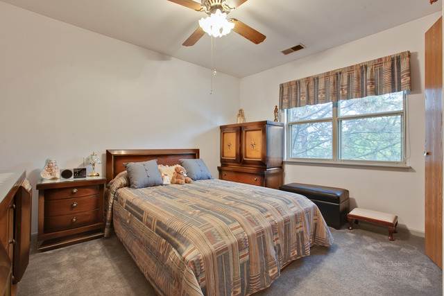 931 Ridgefield Lane Wheeling, IL 60090 - Photo 11 of 20 a bedroom with a large bed and a chandelier fan