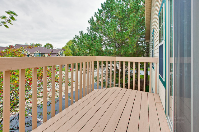931 Ridgefield Lane Wheeling, IL 60090 - Photo 16 of 20 a balcony with wooden floor and fence