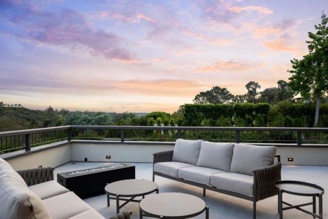 a view of a roof deck with couches and sky view