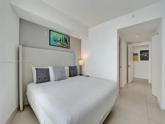 a large bed sitting in a bedroom next to a window