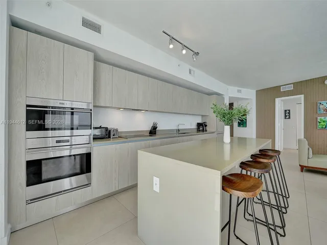 a kitchen with stainless steel appliances kitchen island a table and chairs in it