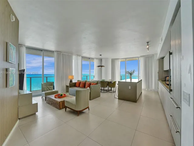 a view of a patio with a table and chairs under an umbrella with a barbeque grill and plants
