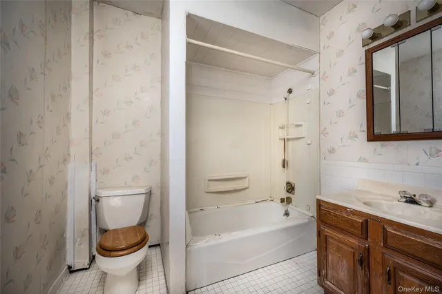 a bathroom with a granite countertop toilet a sink and bathtub