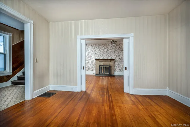 a view of empty room with wooden floor and fireplace