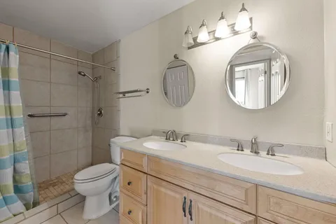 a bathroom with a toilet a sink and mirror