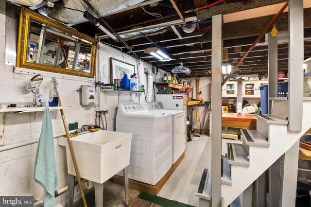 a utility room with dryer washer and stair