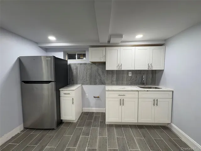 a kitchen with a refrigerator sink and cabinets