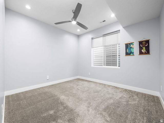 877 South Yarrow Drive Mapleton, UT 84664 - Photo 23 of 46 Neutral-toned carpeted room featuring a ceiling fan with integrated lighting, recessed ceiling lights, a window with a roller shade, and white baseboards