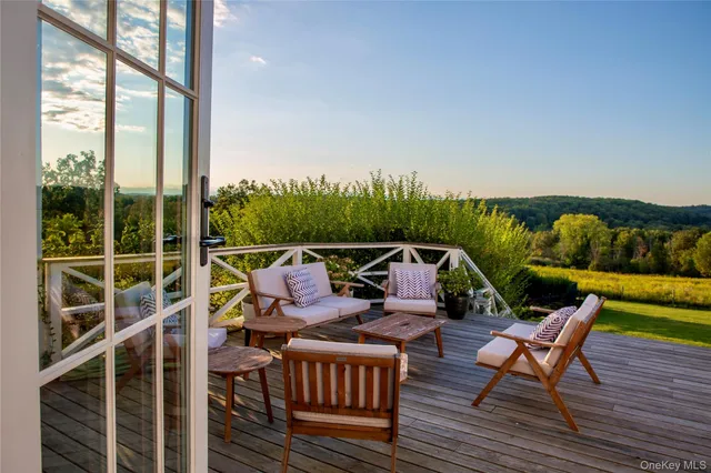a balcony with wooden floor and outdoor seating