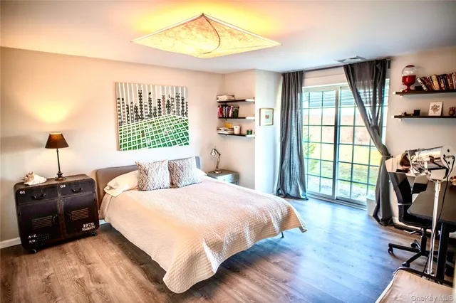 a bedroom with a bed window and flat screen tv