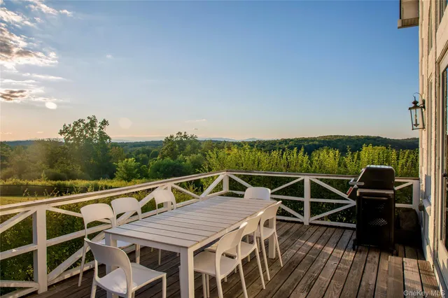 a view of a roof deck with couches and wooden floor