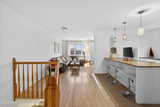 a kitchen with stainless steel appliances kitchen island granite countertop a refrigerator and a sink