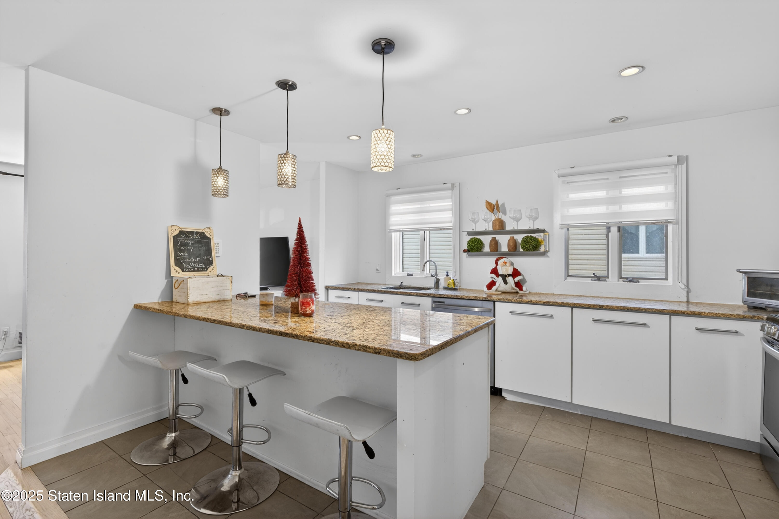 70 Annadale Road Staten Island, NY 10312 - Photo 17 of 35 a kitchen with kitchen island white cabinets sink and stove