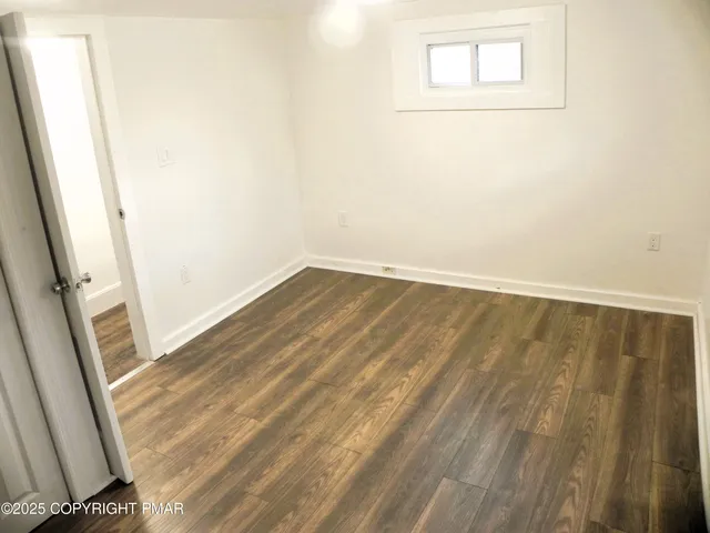 a bathroom with a toilet a sink a window and shower