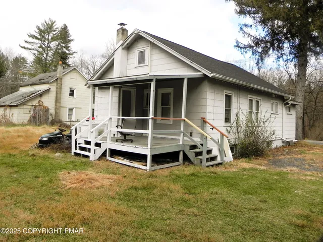 a view of a house with a yard and sitting area