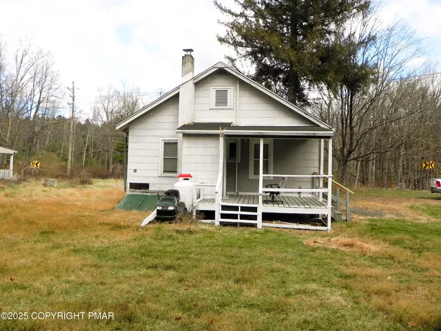 a view of a house with a yard and sitting area