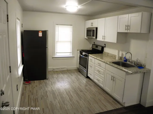 a kitchen with a sink a refrigerator and window