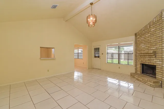 a view of empty room with wooden floor and fireplace