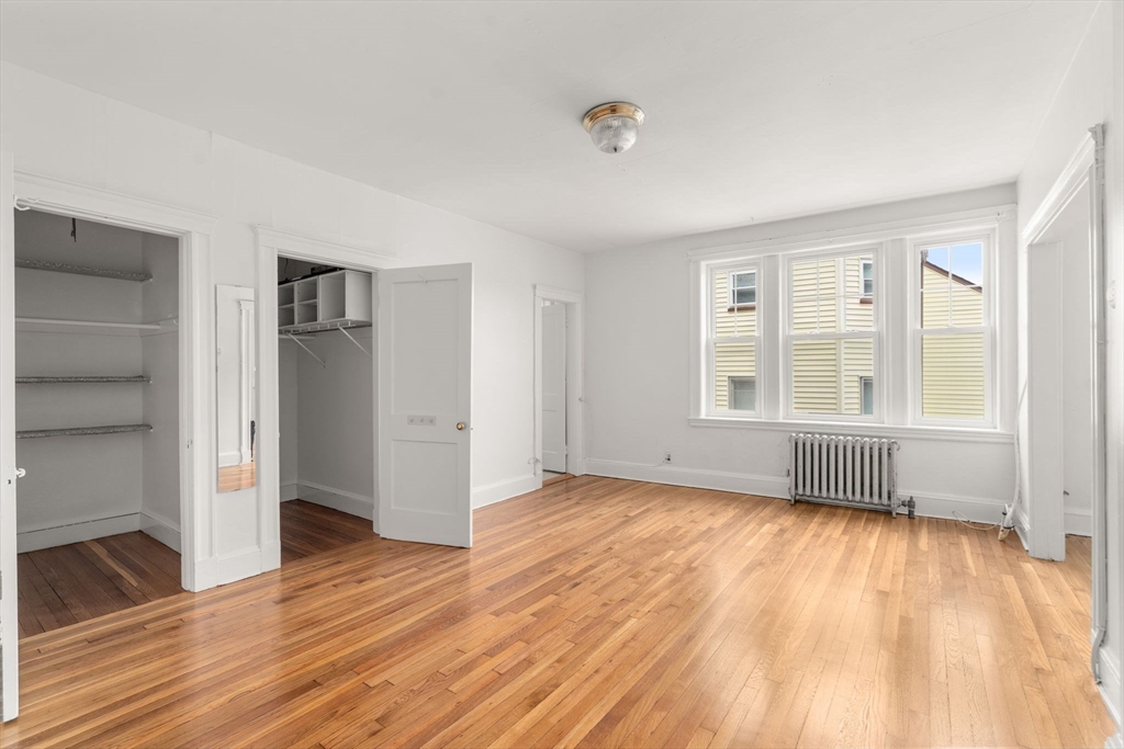 97 Chester Street, Unit 8 Boston, MA 02134 - Photo 15 of 19 an empty room with wooden floor and windows