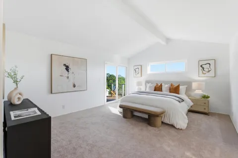 a bedroom with a bed and a large window