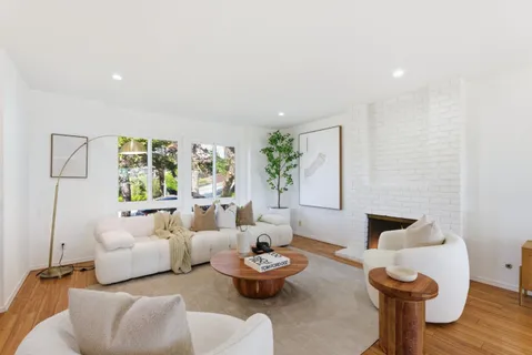 a living room with furniture a fireplace and a large mirror