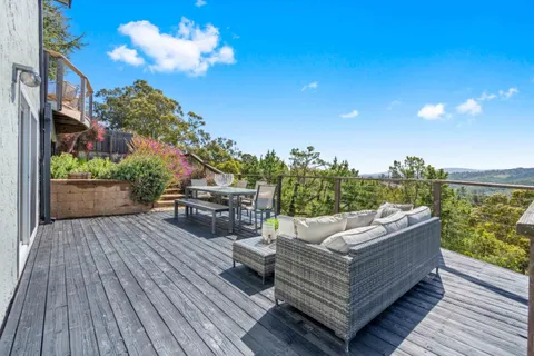 a view of a hallway with wooden floor and a livingroom with furniture