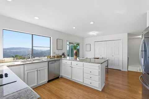 a kitchen with a sink window and cabinets