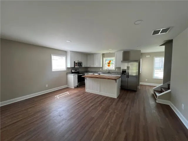 a kitchen with wooden floors and stainless steel appliances