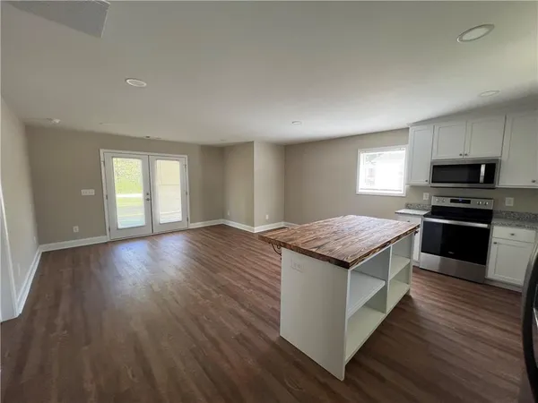 a kitchen with granite countertop wooden floors and stainless steel appliances