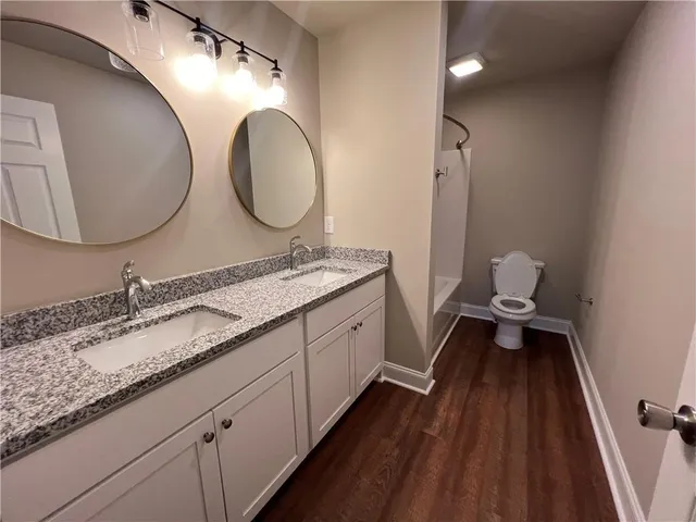 a en suite bathroom with a granite countertop double vanity sink and a mirror