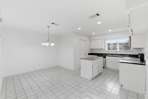 a kitchen with granite countertop white cabinets and white appliances