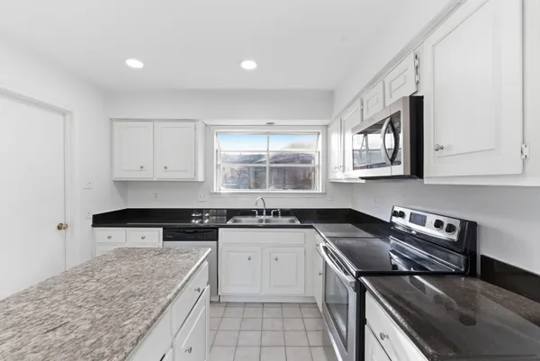 a kitchen with a stove sink and cabinets