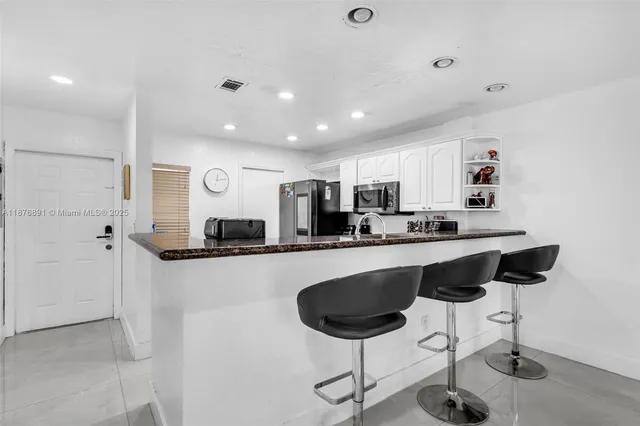 a kitchen with stainless steel appliances granite countertop a refrigerator and a stove top oven