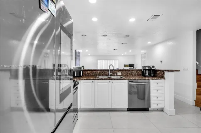 a kitchen with stainless steel appliances kitchen island granite countertop a sink and cabinets