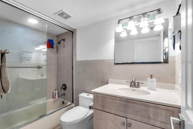 a bathroom with a sink toilet mirror and shower