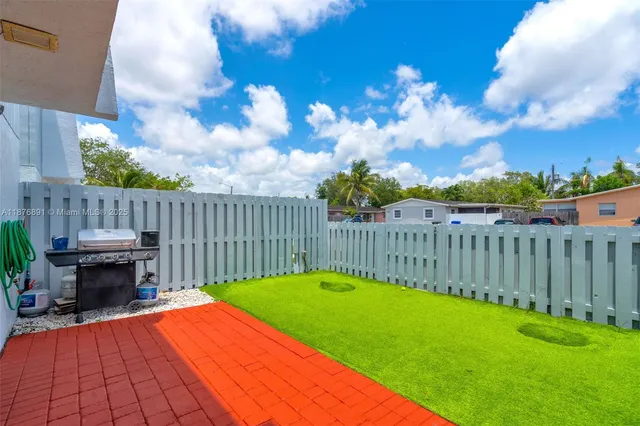 a view of a backyard with a small cabin and wooden fence